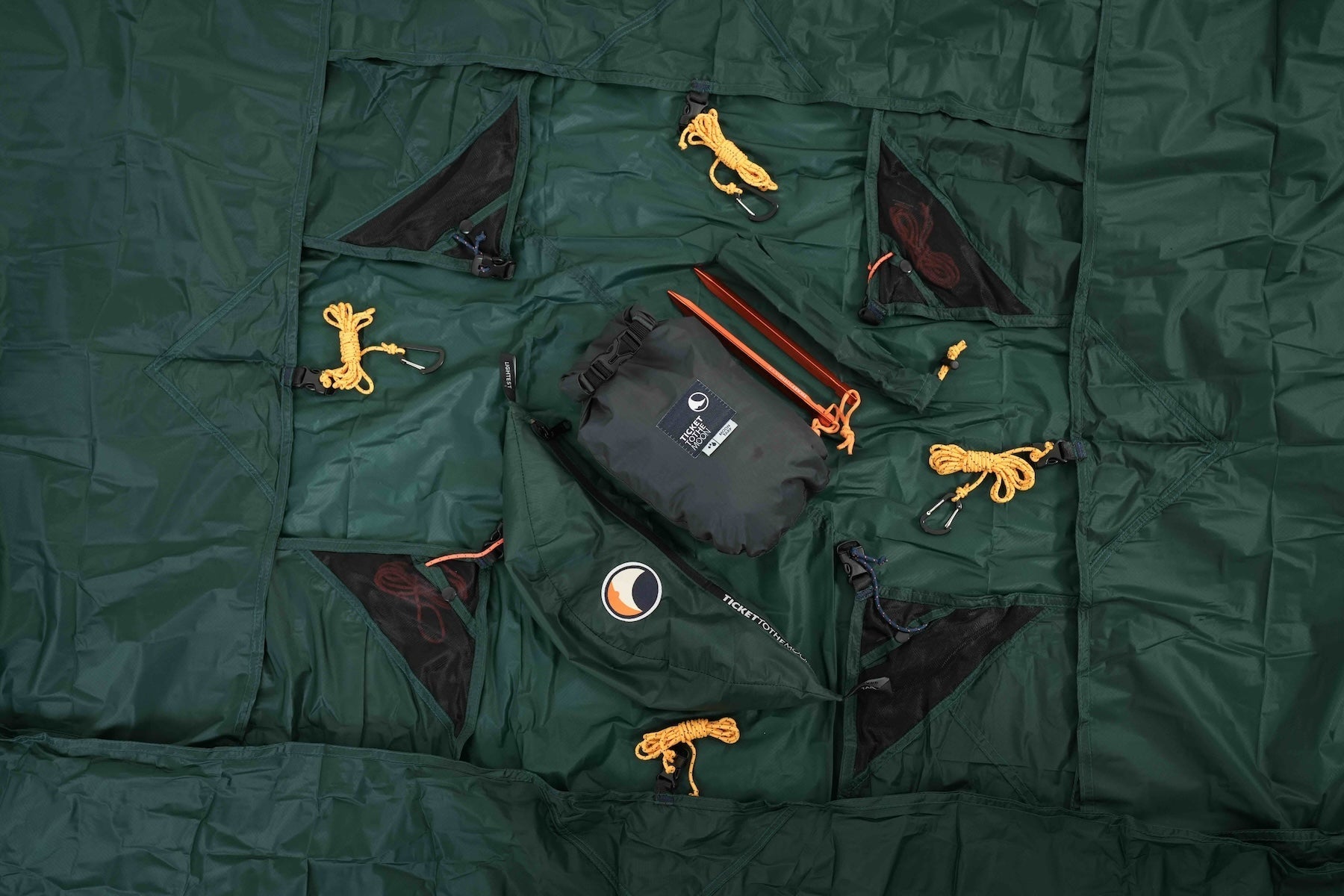 Lieferumfang des LIGHTEST TARP: Heringe, Abspannleinen, Packsack und verstautes Tarp – kompakt und einsatzbereit.