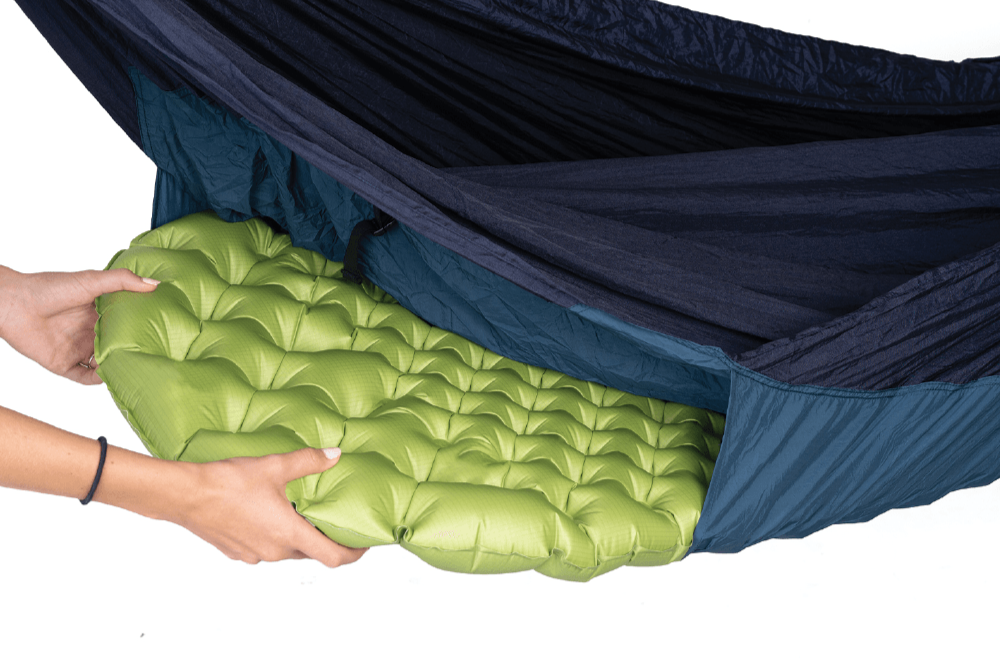 Detailaufnahme: Eine grüne Isomatte wird in das Matratzenfach der MAT HAMMOCK geschoben – zeigt die einfache Handhabung und clevere Konstruktion.