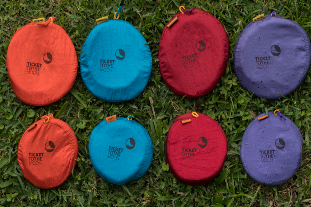 Acht Moondiscs in verschiedenen Farben liegen in zwei Reihen auf grünem Gras, einige mit „Ultimate“ und „Pocket“-Tags.