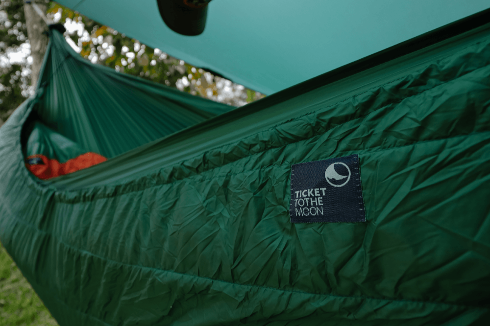Detailansicht des grünen MoonQuilt Pro 850 Underquilts an einer Hängematte – für maximale Wärmeisolierung beim Outdoor-Schlafen.