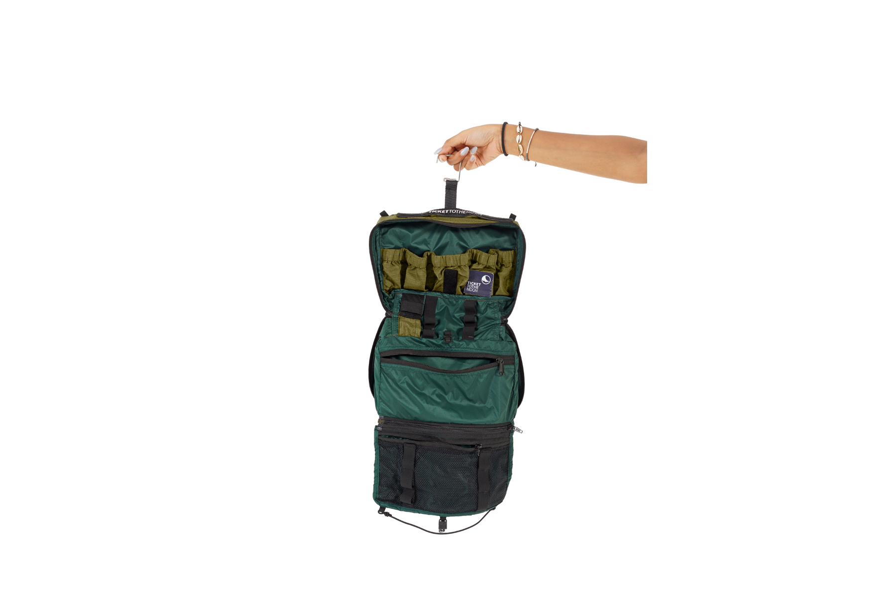 Geöffnete grüne Washbag von Ticket to the Moon wird an einer Hand am integrierten Haken gehalten – mit elastischen Innenfächern, Reißverschlussfächern und Netztasche für optimale Organisation unterwegs.