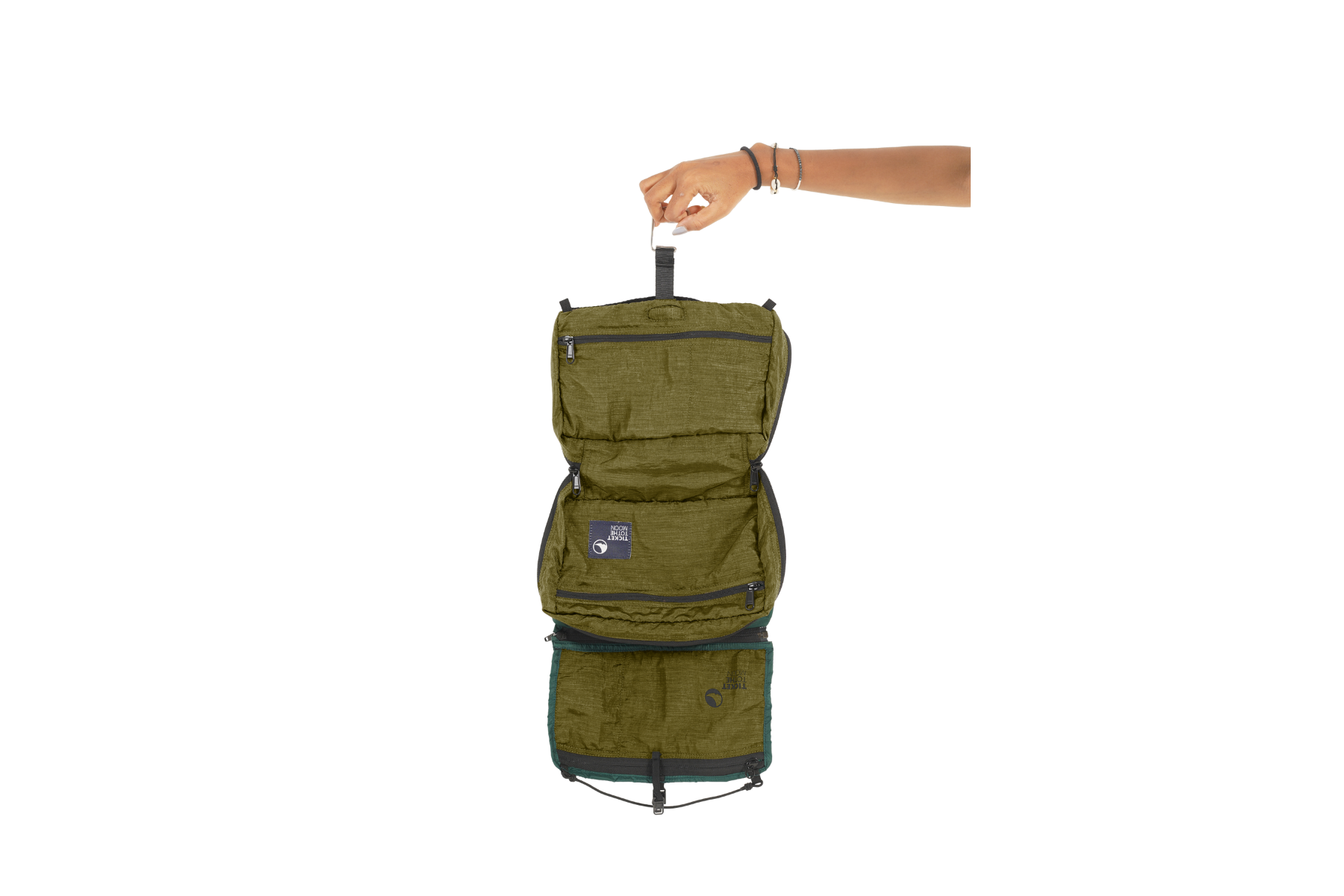 Komplett geöffnete Washbag von Ticket to the Moon in Olivgrün, gehalten an einem integrierten Haken – mit mehreren Reißverschlussfächern und viel Stauraum für Reiseutensilien.
