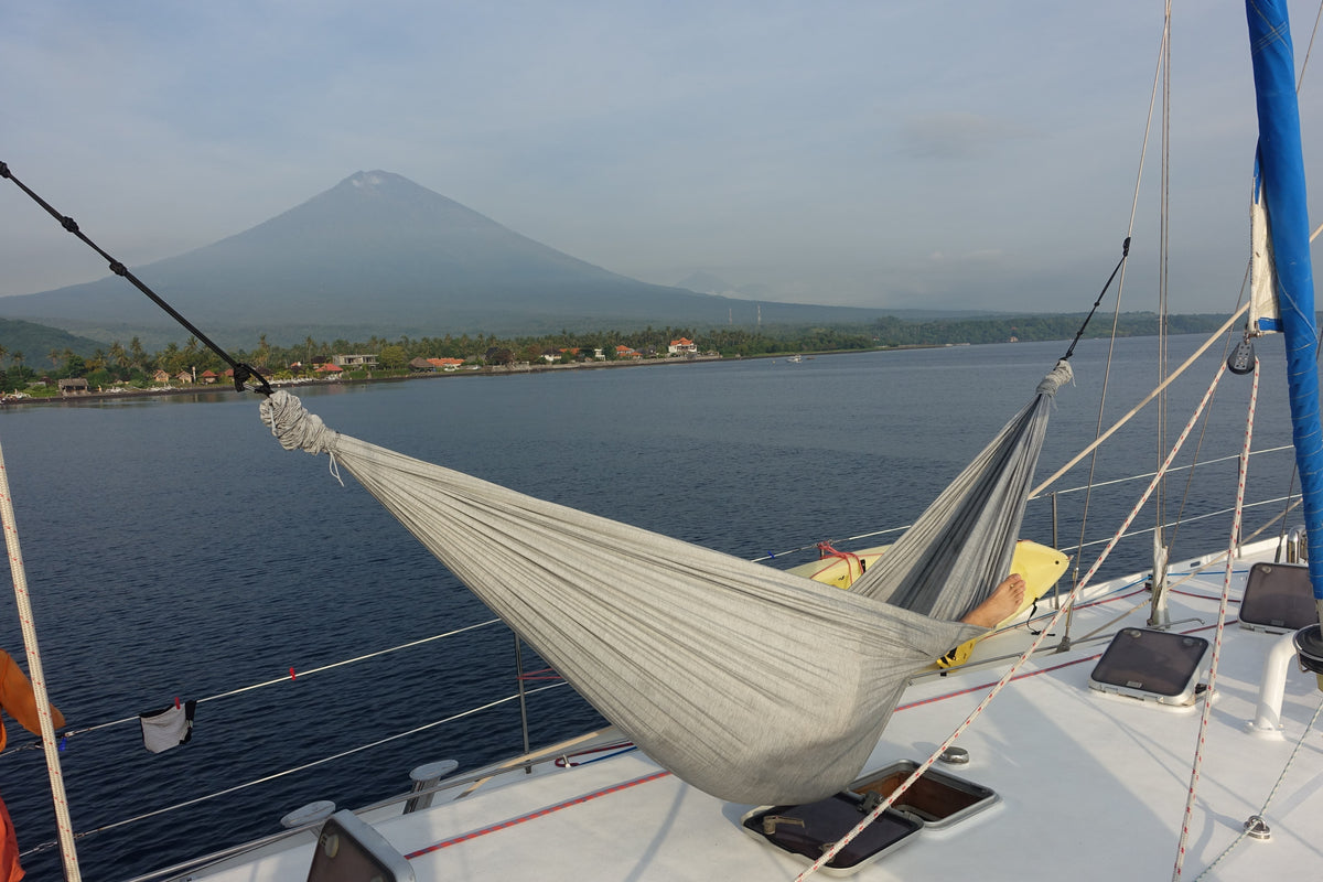 Home Hammock 320 in Frosty Grey an Deck eines Segelboots, gegenüber in der Bucht ein Vulkan