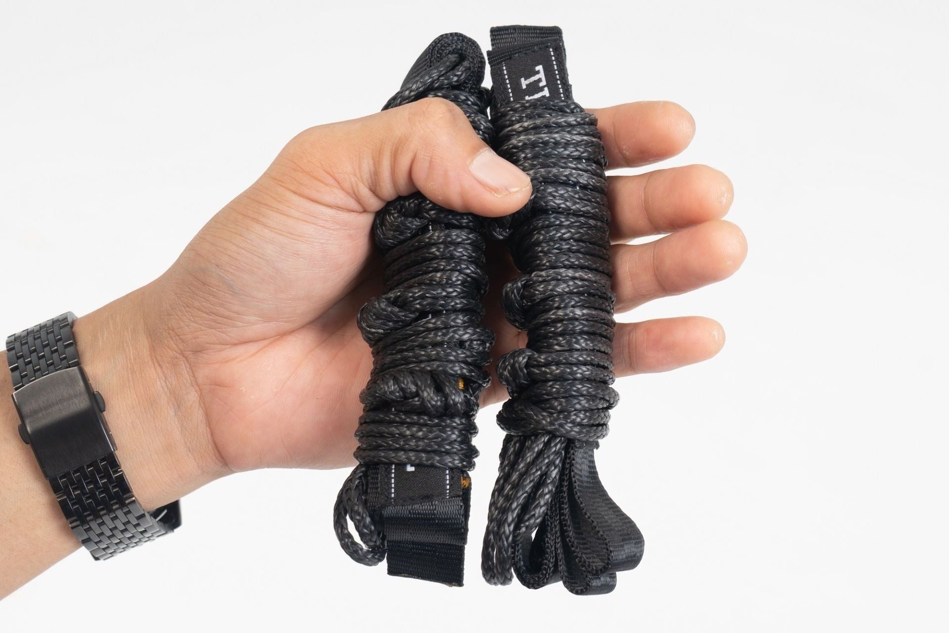 Eine Person hält zwei Lightest Straps - die ultraleichte Hängematten-Aufhängung von Ticket to the Moon in der Hand.