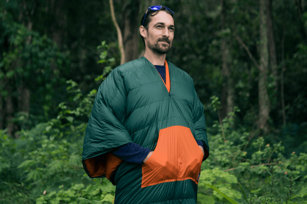 Moonblanket in grün und orange – vielseitige Decke von Ticket to the Moon, als Poncho getragen in der Natur
