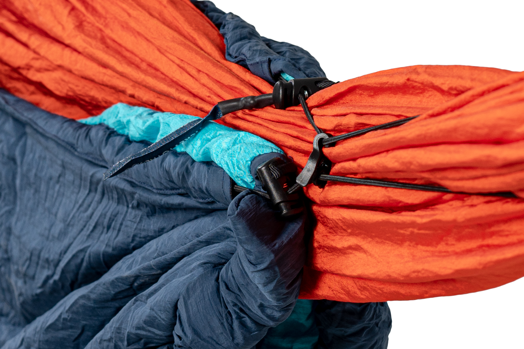 Detailaufnahme des MOONQUILT Compact in blau – montiert an einer roten Hängematte für optimalen Kälteschutz beim Outdoor-Schlaf.