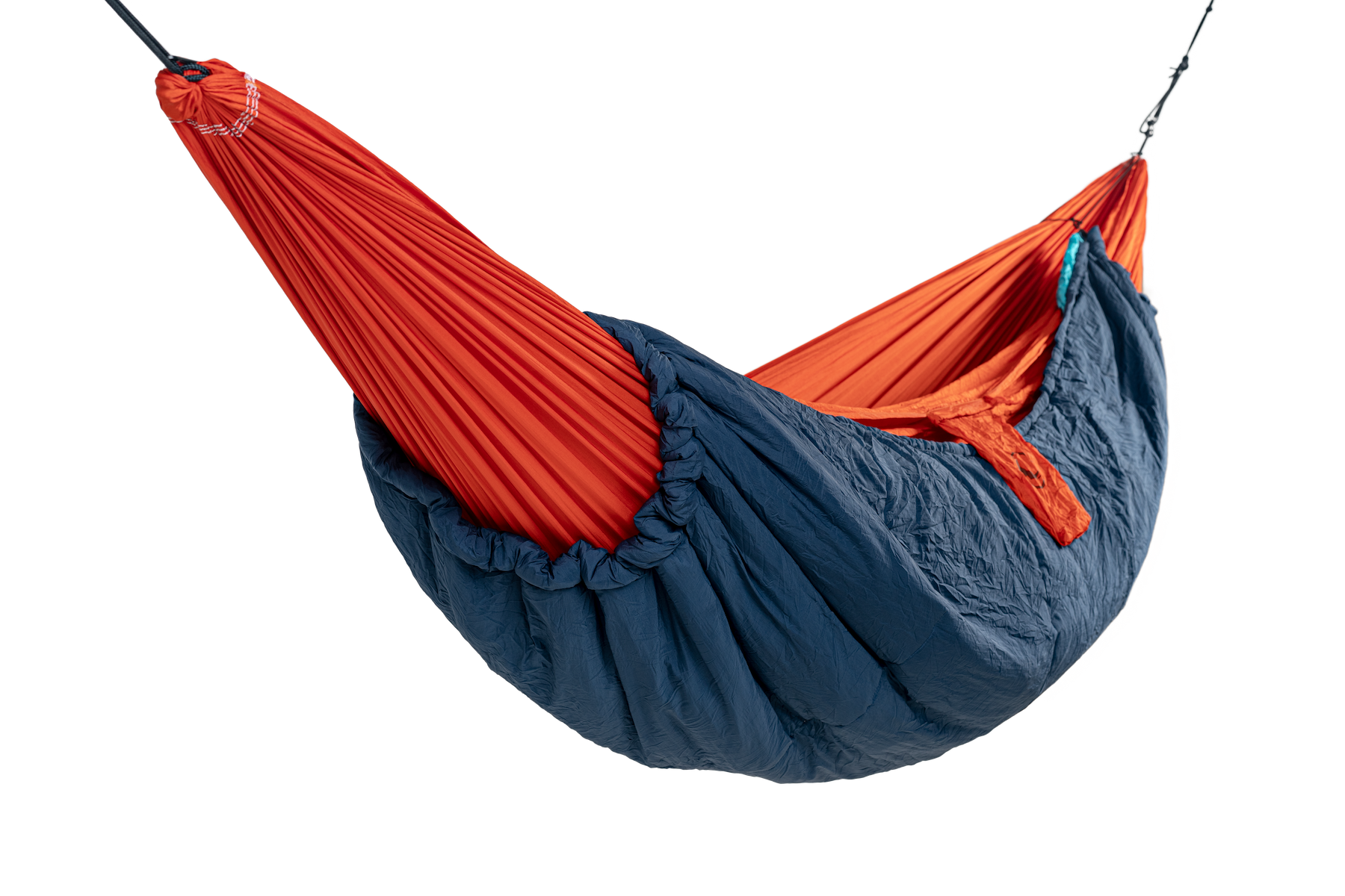 Detailaufnahme des MOONQUILT Compact in blau – montiert an einer roten Hängematte für optimalen Kälteschutz beim Outdoor-Schlaf.