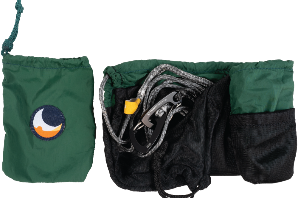 Grüner Packsack mit Ticket to the Moon Logo und geöffnete Ridgeline-Ausrüstung mit Seil, Karabinerhaken und Netzbeutel, freigestellt vor transparentem Hintergrund
